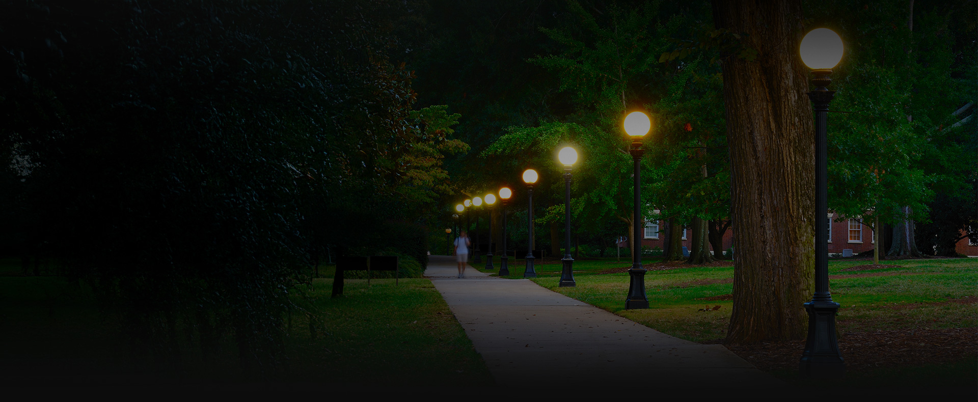 college campus man walks on sidewalk