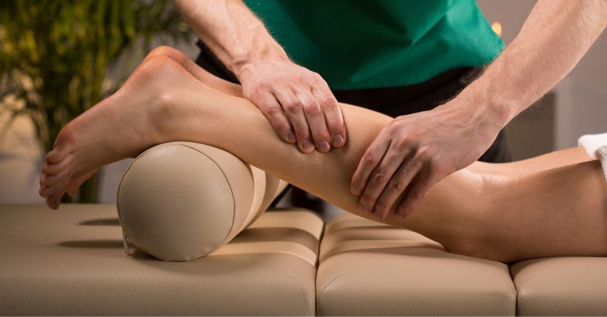 Massaging a person's calf muscle