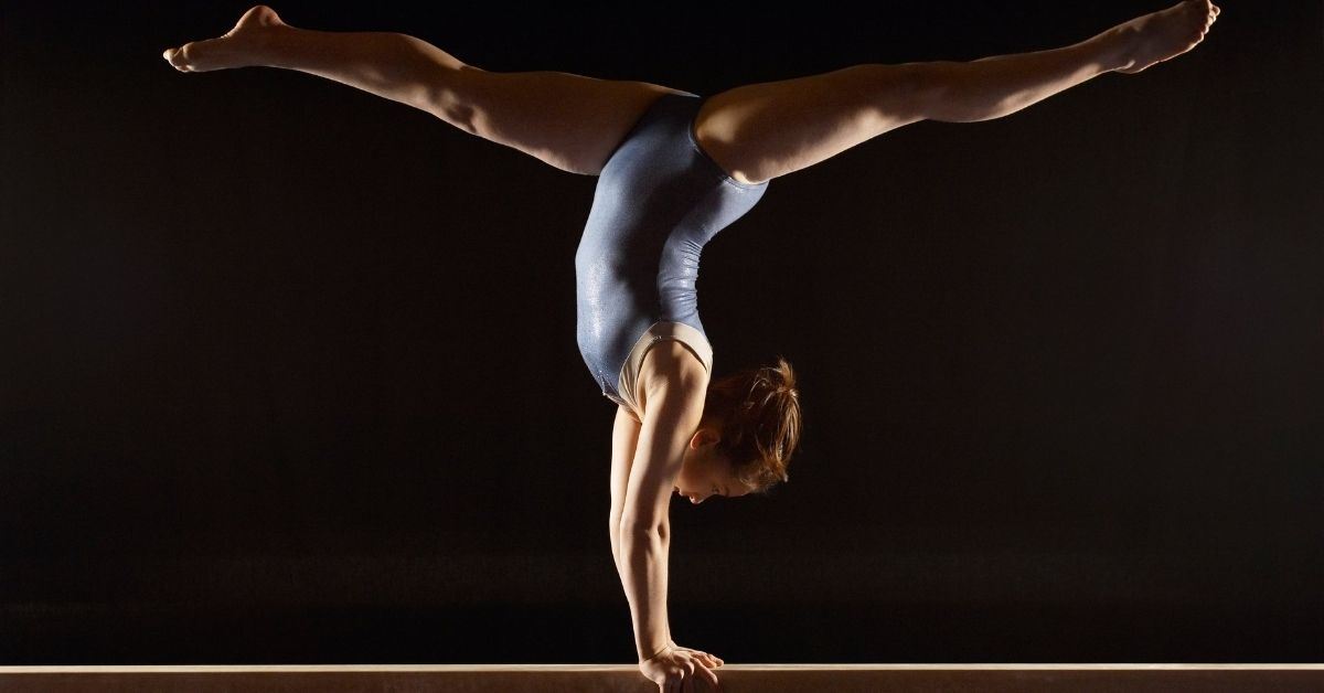 Gymnast doing a handstand on bar