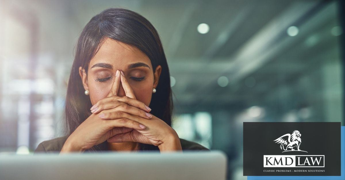 Woman with eyes closed sitting in front of computer