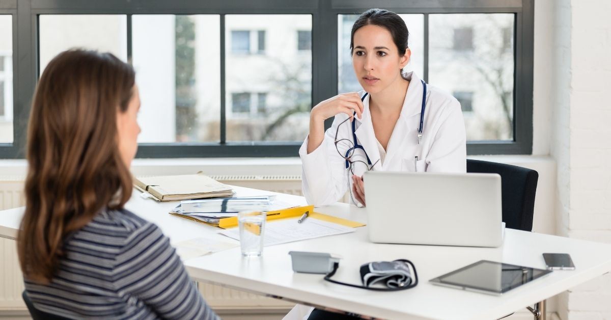 Doctor sitting at desk talking to patient
