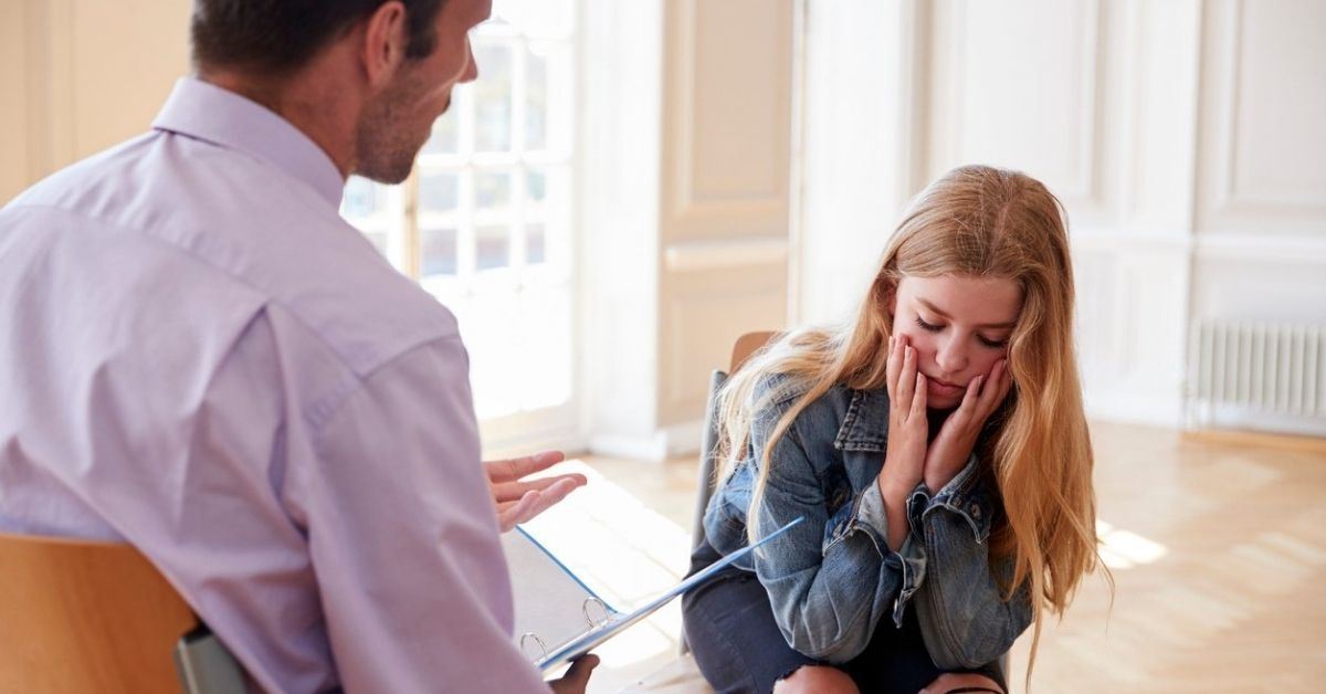 Man talking to woman in chair