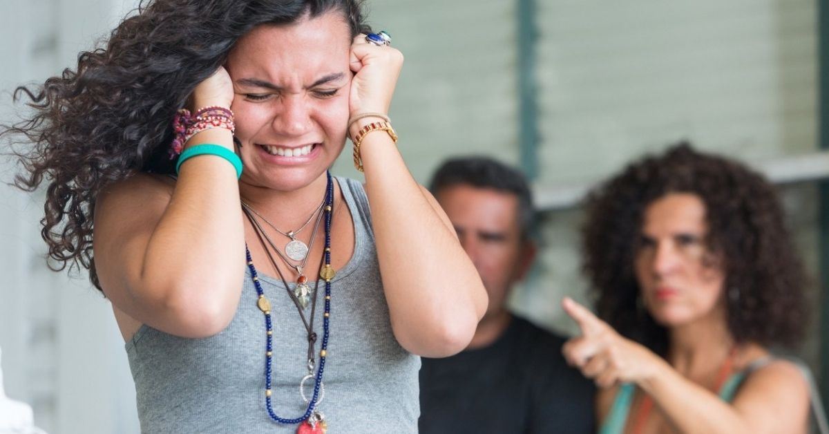 Upset woman with hands over ears