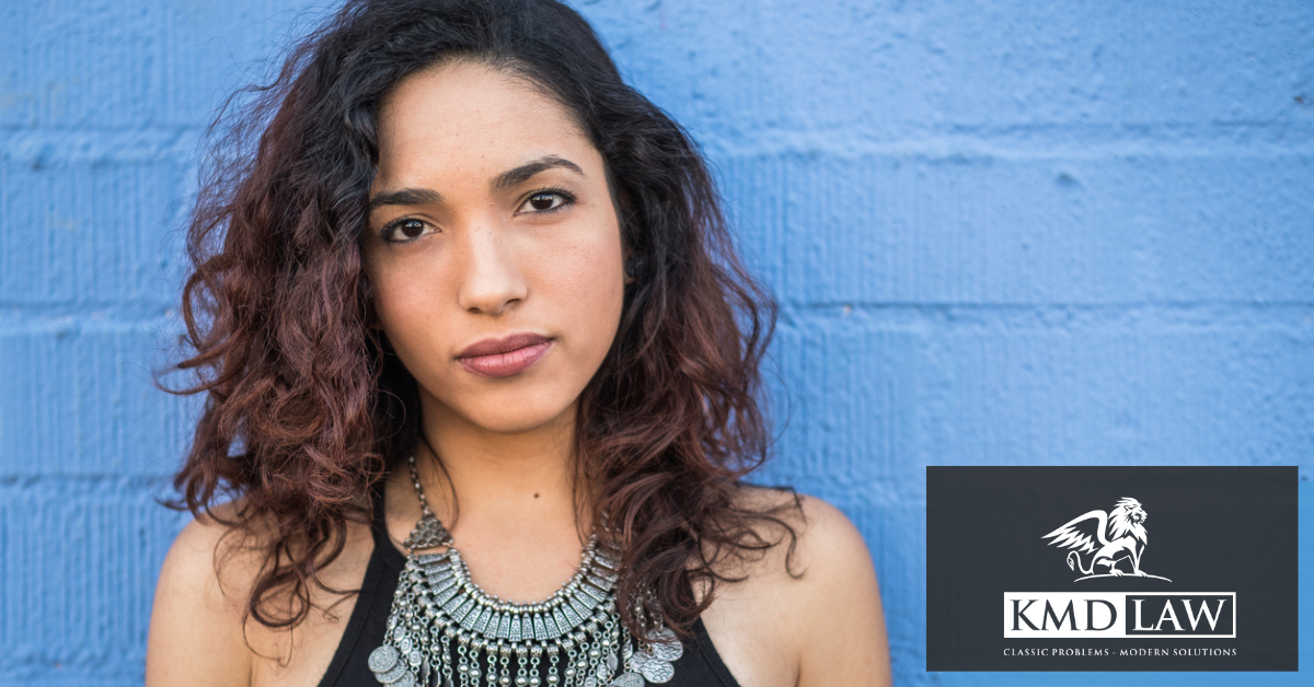 Woman standing against a blue wall looking forward