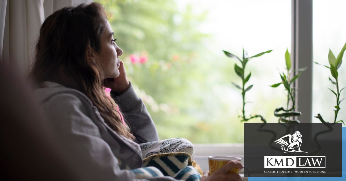 Woman staring out window holding mug