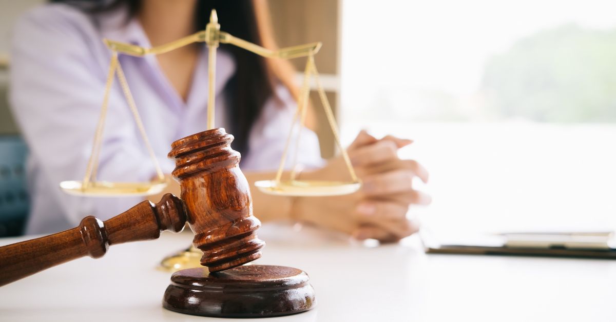 Gavel in front of a woman sitting at a desk