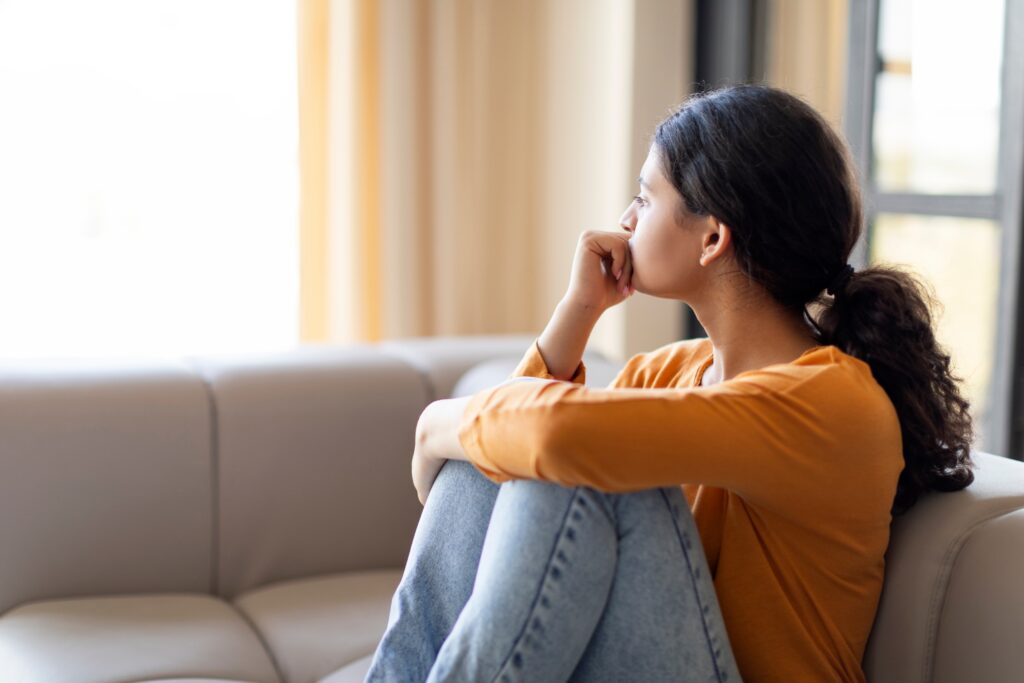 Woman thinking sitting on couch