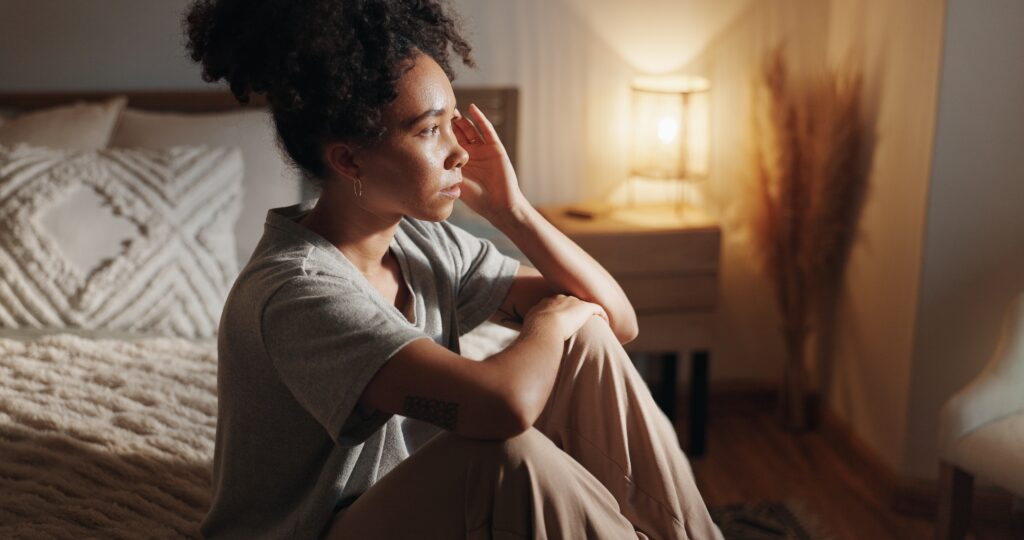 Woman thinking while sitting on bed