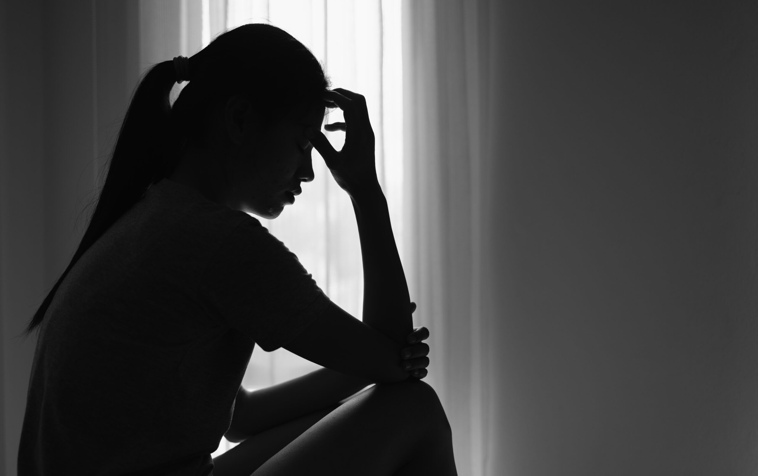 Young women sitting in dark room