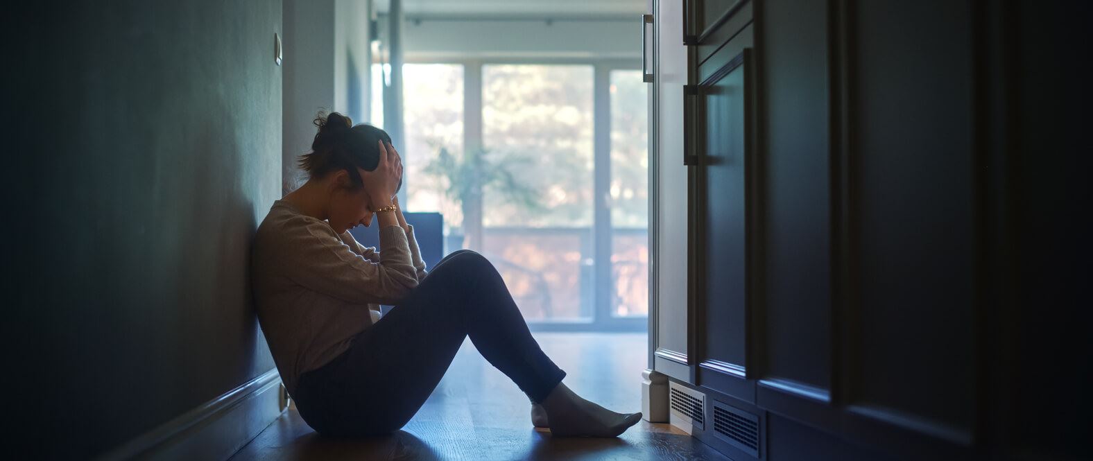 Woman sitting on floor in hallway