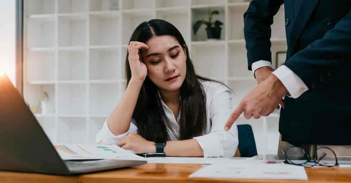Woman sitting at desk being shown information