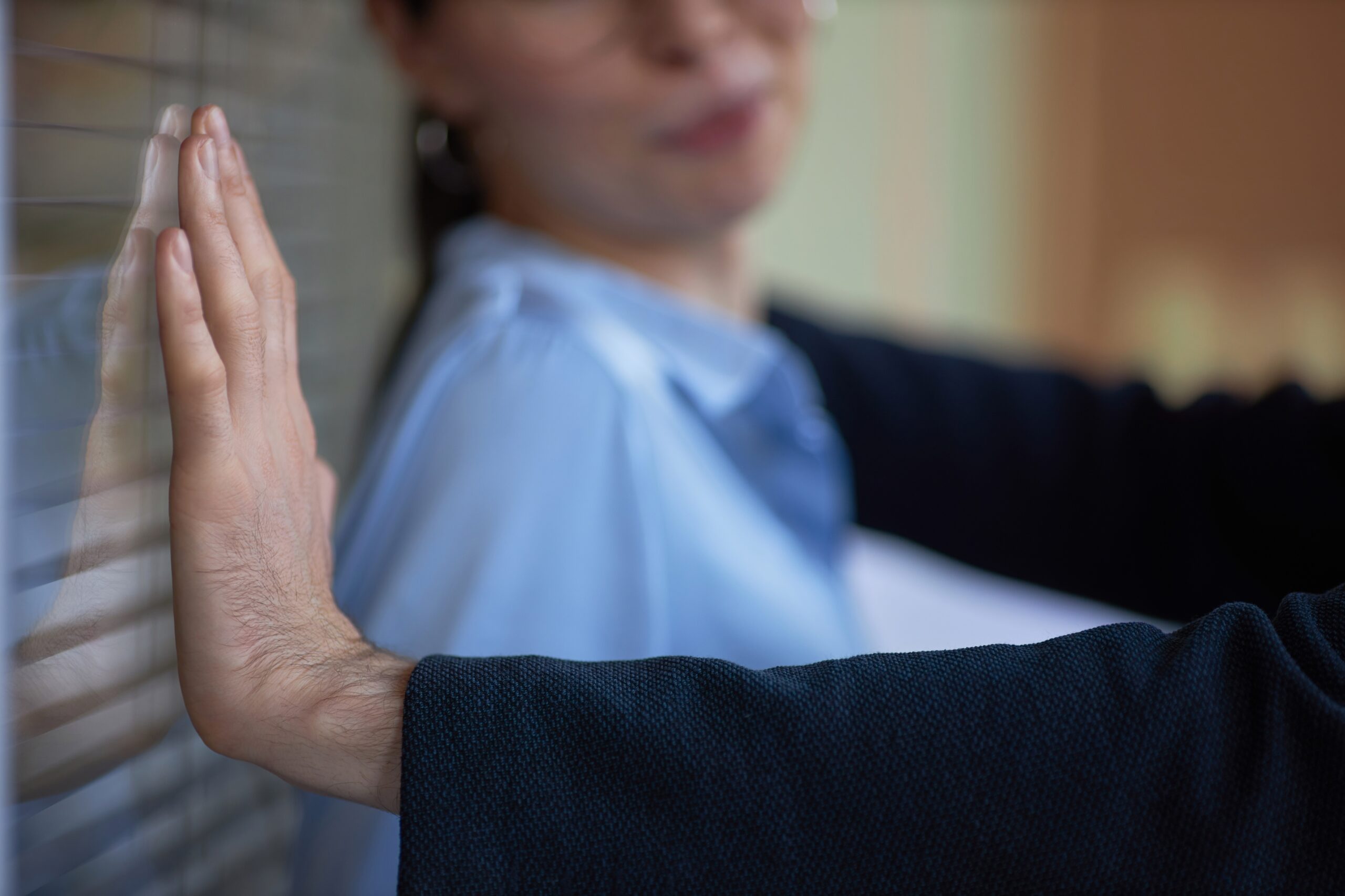 Closeup of man pushing woman against wall in office, workplace harassment scene